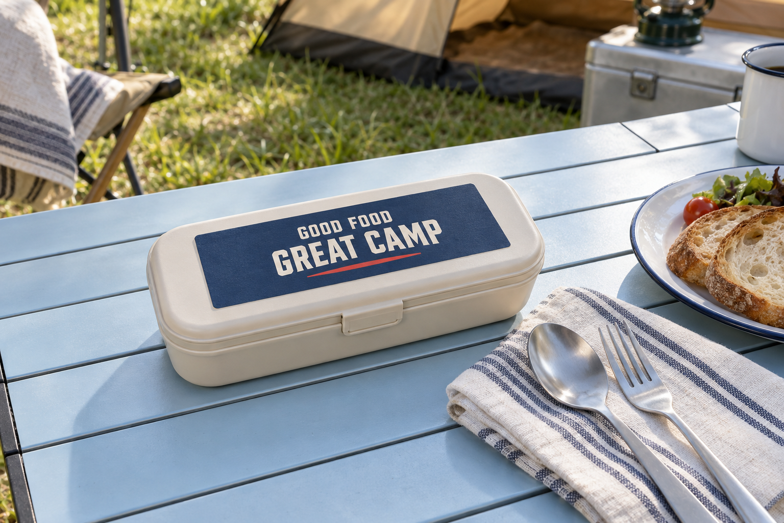 キャンプの食卓に置いたGOOD FOOD GREAT CAMPの文字入りカトラリーケース